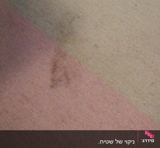 שטיח עם כתמים כהים על רקע בהיר